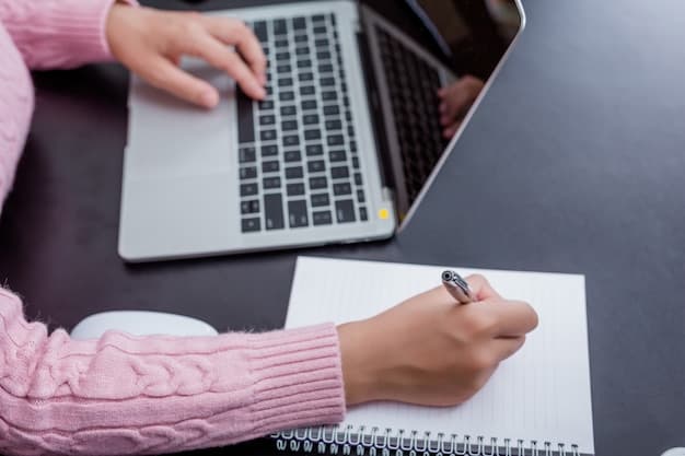 A realistic photo of a person focused on editing content on a laptop with a notebook nearby